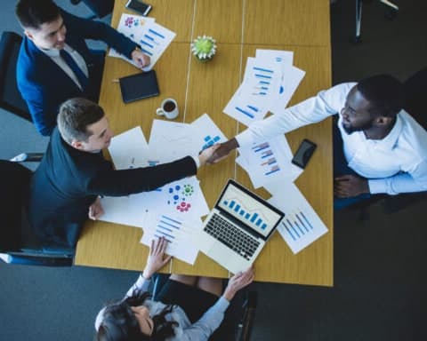 Sala de reunião corporativa com equipe em torno de uma mesa longa