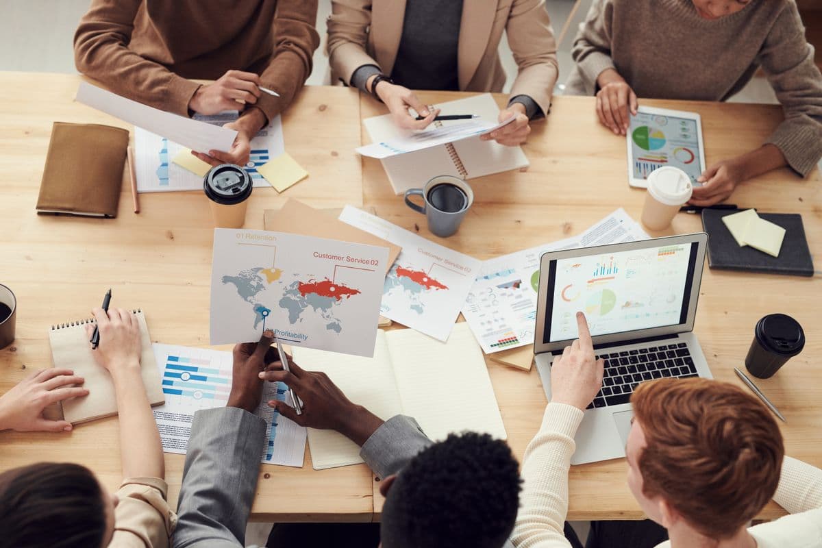 Equipe analisando relatórios e gráficos de marketing sobre a mesa