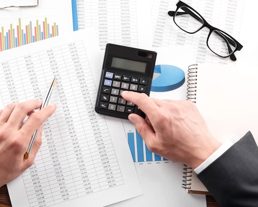 Calculadora e gráficos financeiros sobre a mesa